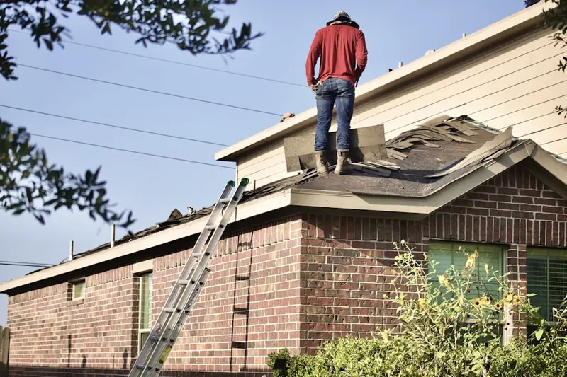 Professional roofer working on a residential roof in West University